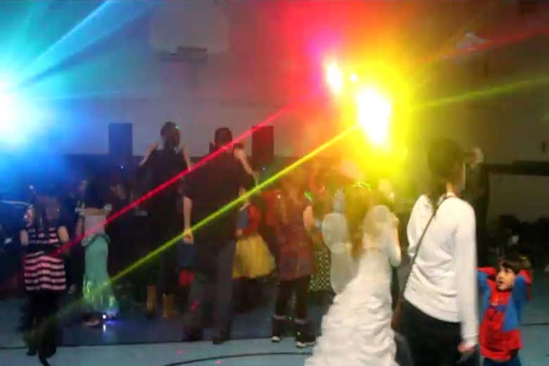 School Light Show, Hamilton DJ, Family Dance, guests dancing with laser beams & special  effects beams  everywhere, Blue flash of light with blue beams on left. Red & yellow flashes of light with red & yellow beams. Taken in Hamilton.